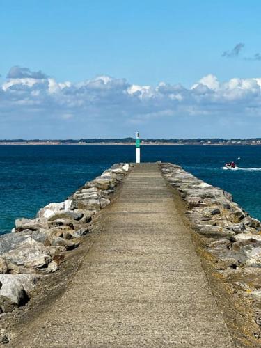 a pathway leading into the ocean with a lighthouse at Location Mobil-Home "Le Piriac'Home V2" in Piriac-sur-Mer