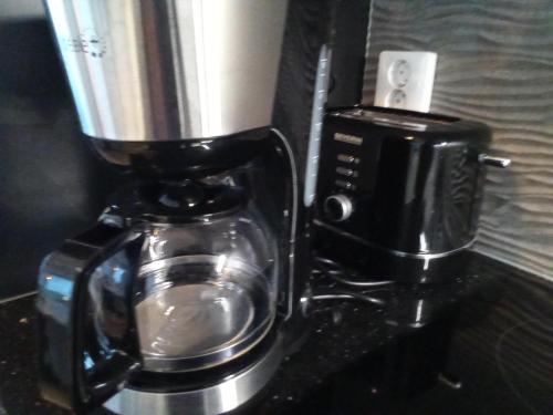 a black coffee maker with a coffee pot at TAMPERE PENTHOUSE-tasokas moderni kaupunki huoneisto huipulla -ISO JACUZZI omalla KATTOTERASSILLA - AURINKOTUOLIT ja Aurinko odottaa Sinua - huikea maisema- - 10 HLÖ - free parking in Tampere