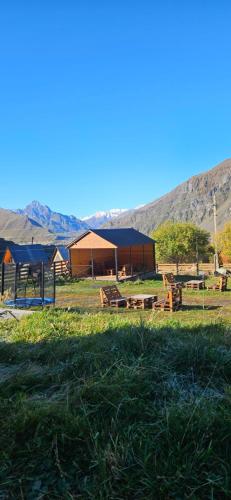 a group of tents in a field with mountains in the background at Misty Rocks Kazbegi in Stepantsminda