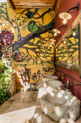 a bathroom with three sinks and a painting on the wall at Mamachá - Natural Residence in Valladolid
