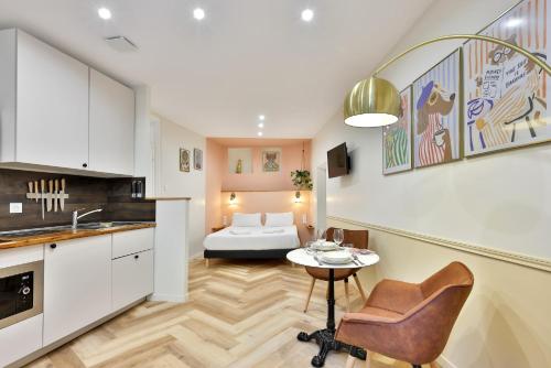 une cuisine et un salon avec une table et un canapé dans l'établissement Le Chic & Biscornu - Terrasse - Clim - Centre Ville, à Périgueux