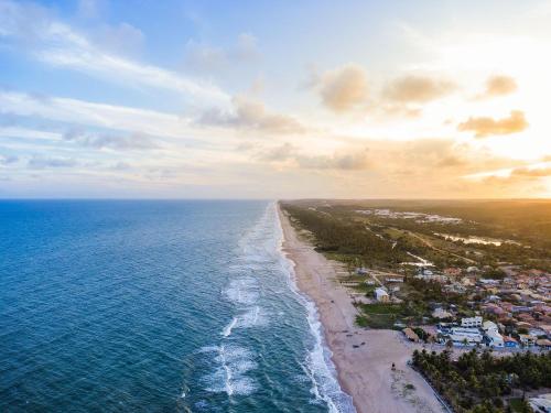 an aerial view of the ocean and a beach at Apartamento em condomínio com passeio incluso in Baixio