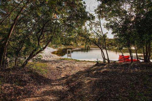 a red boat sitting on the side of a river at Apartamento em condomínio com passeio incluso in Baixio