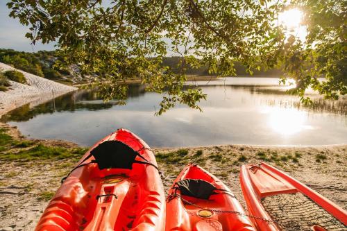 two kayaks sitting on the shore of a lake at Apartamento em condomínio com passeio incluso in Baixio