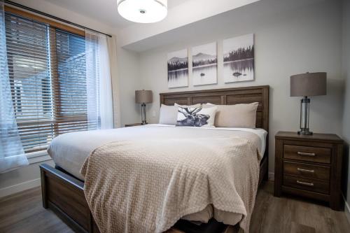 a bedroom with a large bed and a window at Le Bucheron Stunning Spring Creek Luxury condo in Canmore