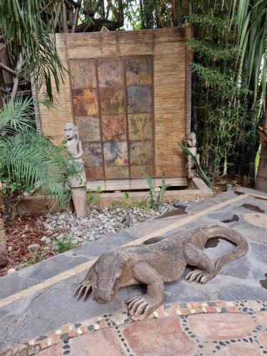 a statue of a lizard laying on the ground at Eco Hotel Tahawi in Ajijic