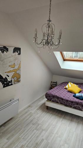 - une chambre avec un lit violet et un lustre dans l'établissement Duplex de 120 m2 7 Pers-Centre-Parking Privé, à Gérardmer
