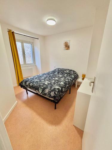 une chambre avec un lit dans une pièce avec une fenêtre dans l'établissement appartement confort, à Gray