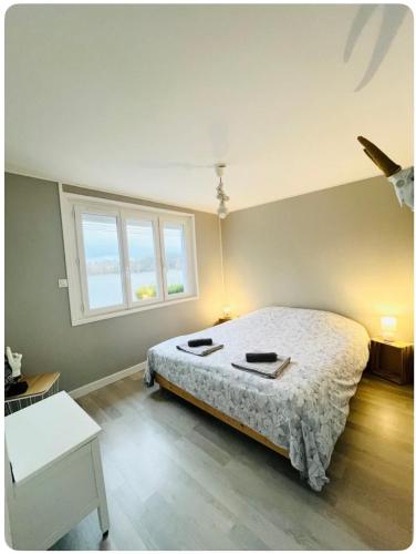 a bedroom with a large bed and a window at Maison Mon p’tit bonheur in Changey