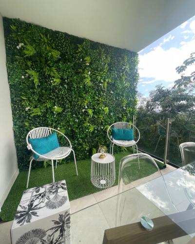 two chairs and a table in front of a green wall at KOAH LODGE Tahiti in Papeete
