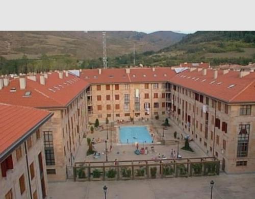 a large building with a courtyard with a swimming pool at Apartamento Parque Europa in Ezcaray