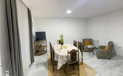 ein Esszimmer mit Tisch und Stühlen und einem Fernseher in der Unterkunft Neno Apartmani in Novi Pazar