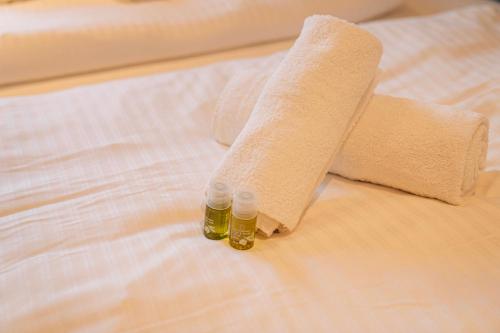 a roll of toilet paper and a bottle of oil on a bed at RR - Penthouse - Luxe 105 qm - Central - WIFI in Magdeburg