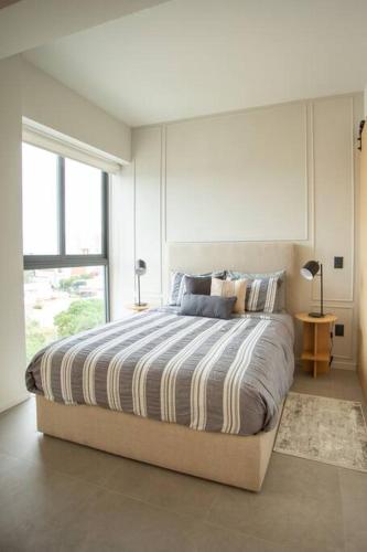 a bedroom with a bed with a large window at MrW Incredible loft in Livify in Guadalajara