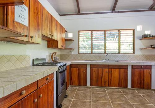 a kitchen with wooden cabinets and a stove top oven at Surfsidelodge in Cabo Matapalo