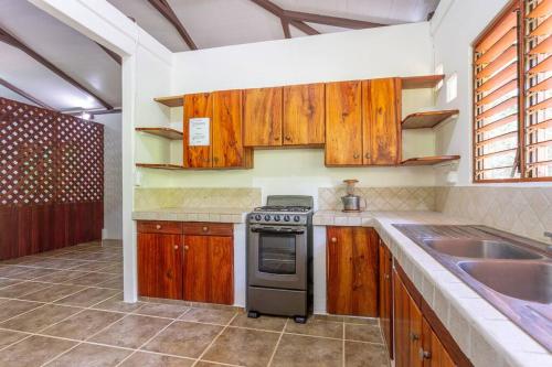 a kitchen with wooden cabinets and a stove top oven at Surfsidelodge in Cabo Matapalo