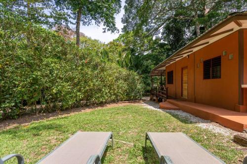a house with two benches in front of a yard at Surfsidelodge in Cabo Matapalo