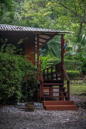 a small building with a staircase in a garden at Surfsidelodge in Cabo Matapalo