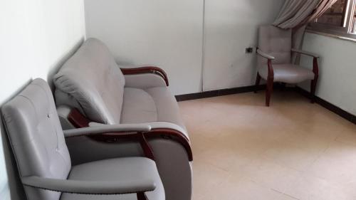 two white chairs in a room with a window at GSF Guest House in Addis Ababa