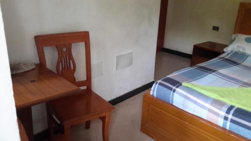a bedroom with a bed and a desk and a chair at GSF Guest House in Addis Ababa