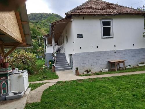 a white house with a table in the yard at seosko turisticko gazdistvo milanovic zuc in Žuč