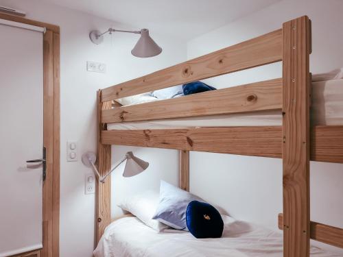 a bedroom with a bunk bed with a wooden bunk bed ladder at Le petit Basque, Plage - Bar - Restaurant in Soorts-Hossegor