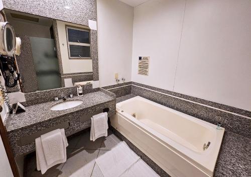 a bathroom with a bath tub and a sink at Riale Imperial Flamengo in Rio de Janeiro