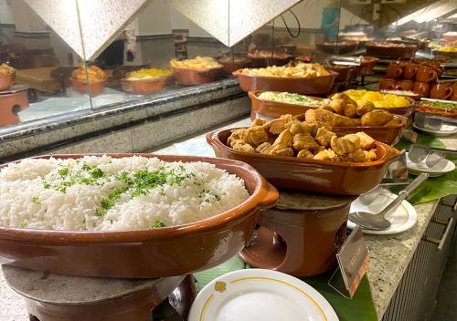 a buffet line with bowls of rice and other food at Riale Imperial Flamengo in Rio de Janeiro