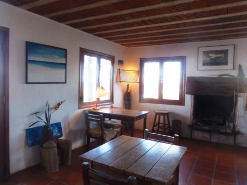 a living room with a table and a fireplace at La Posada in Punta Del Diablo