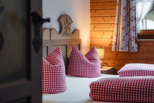 a bedroom with two beds with red and white pillows at Schallerhof in Neustift im Stubaital