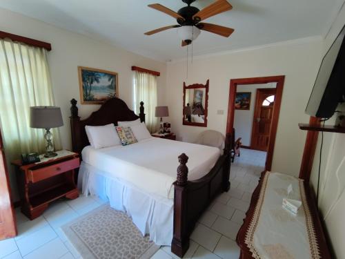 a bedroom with a bed and a ceiling fan at Rayon Hotel in Negril