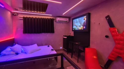a room with a bed and a tv in it at Motel Marselha 5 in Sao Paulo