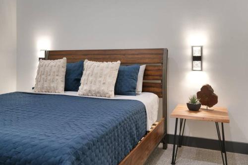 a bedroom with a blue bed with a wooden headboard at Vizcaya #5 - Moab's Newest Luxury Rental with Private Hot Tub in Moab