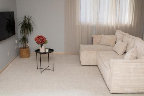 un salon avec un canapé blanc et une table dans l'établissement StudioEurexpo - spacieux & confort, à Chassieu