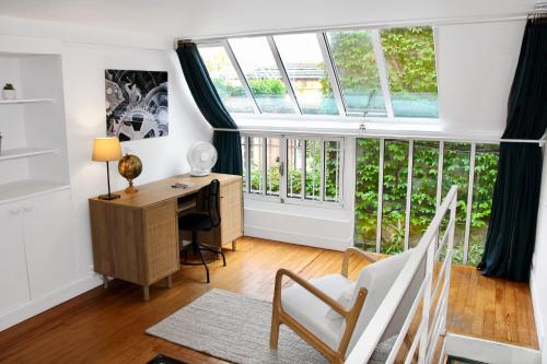 un bureau avec un bureau et des fenêtres dans l'établissement Cozy Artist Loft, à Paris