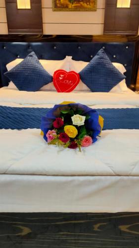 a bouquet of flowers on a bed with a heart at Sri Krishna Residency in Varanasi