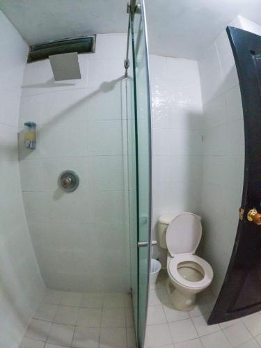 a bathroom with a toilet and a glass shower at Santorini Apartamentos Amoblados in Pereira