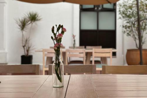 a glass vase with flowers sitting on a table at Hotel La Casa de María in Oaxaca City