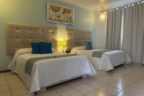 a bedroom with two beds in a room at Hotel La Casa de María in Oaxaca City