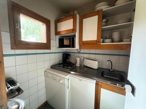 une petite cuisine avec un évier et un comptoir dans l'établissement Résidence Les Glaciers 1 Et 2 - Studio fonctionnel · Accès direct aux pistes · Vue sur la vallée MAE-3778, à Mâcot La Plagne