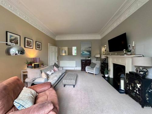 a living room with a couch and a fireplace at Stylish Murrayfield sanctuary in Edinburgh