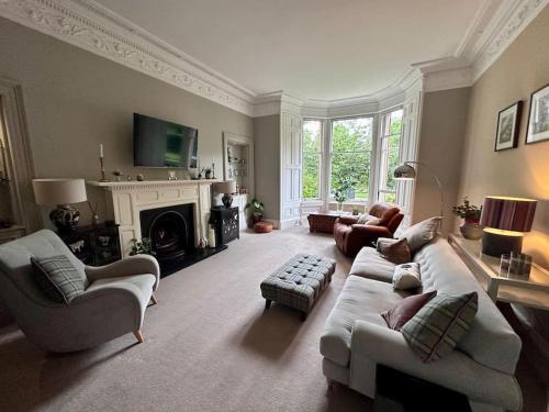 a living room with a couch and chairs and a fireplace at Stylish Murrayfield sanctuary in Edinburgh