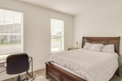 a bedroom with a bed and a chair and windows at Family-Friendly Townhome in Murfreesboro! in Murfreesboro