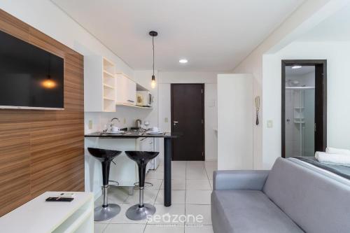 a living room with a couch and a table in a room at SPT - Studios Convenientes em Blumenau/SC in Blumenau