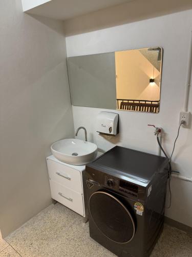 a small bathroom with a sink and a washing machine at Twenty Two Place Sukhumvit 22 in Bangkok