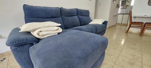 a blue couch with two pillows on top of it at הנביאים 1 נתניה Naveim apartment in Netanya