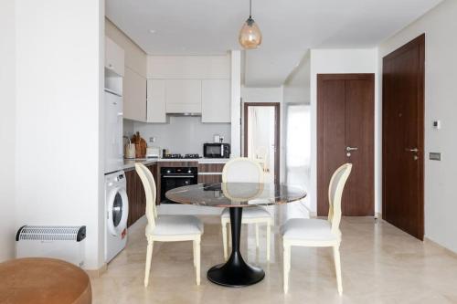 a dining room with a table and chairs in a kitchen at Luxury Eagle Hills Apartment in Rabat