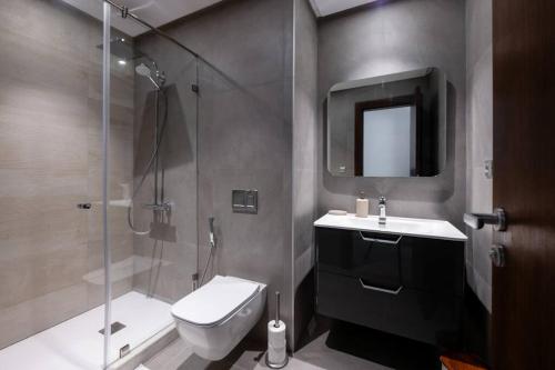 a bathroom with a shower and a toilet and a sink at Luxury Eagle Hills Apartment in Rabat