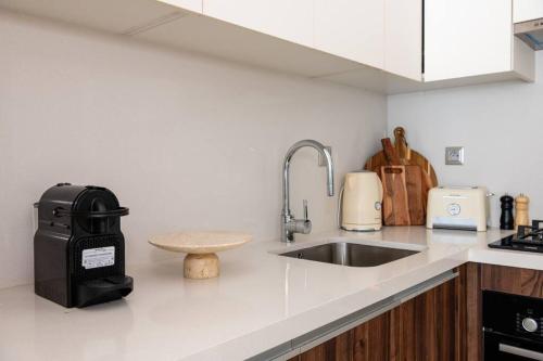 a kitchen counter with a sink and a trash can at Luxury Eagle Hills Apartment in Rabat