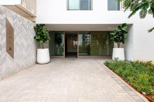 a building with two potted plants in front of it at Luxury Eagle Hills Apartment in Rabat